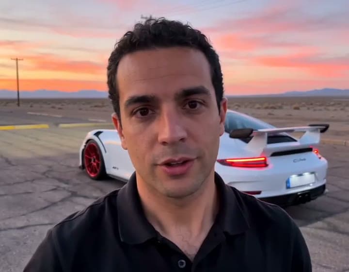 The reveal frame of a generated 24 trend car video: a white sports car with red wheels parked behind the man